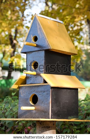 funny three-storeyed starling-house on autumn park background