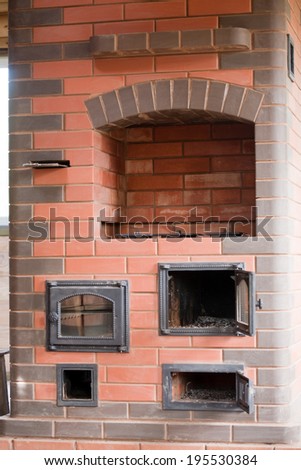 brick facade closeup of big house stove with metal doors and decorated cooker
