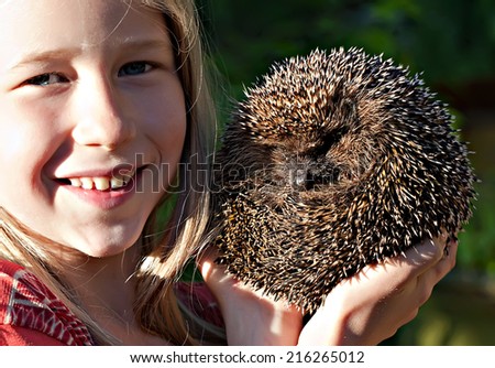 little smiling girl with cute hedgehog ball in hands