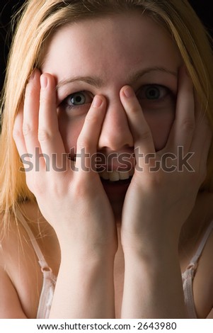 portrait of young girl with hands at her face in happy surprise gesture
