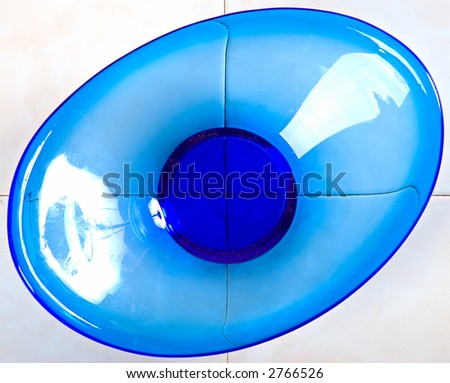 view from above of blue glass dish on white tiled table