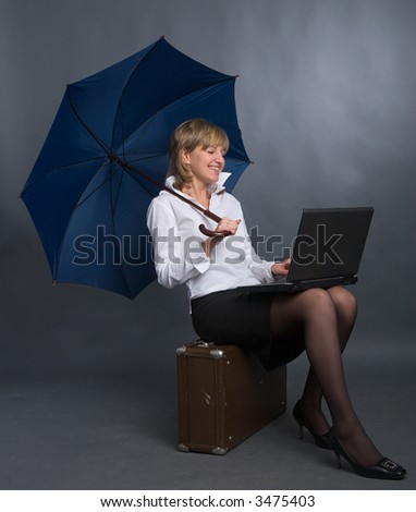 young beautiful woman with umbrella, suitcase and laptop