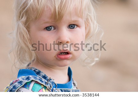 portrait of two years old sad blond girl