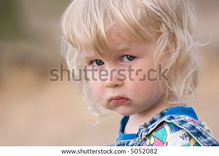 portrait of two years old sad blonde girl
