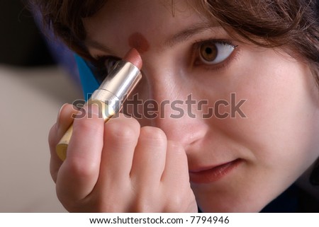beautiful woman making up her face with lipstick