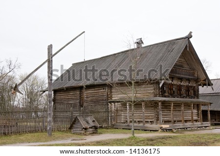 big wooden house and well in Russian village