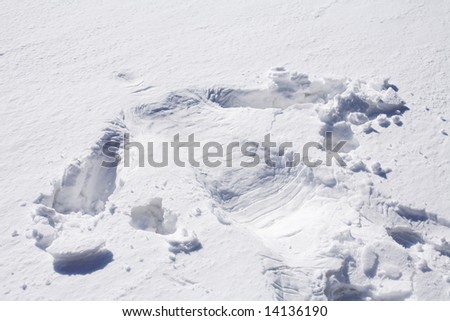 silhouette of human body imprint on soft snow surface