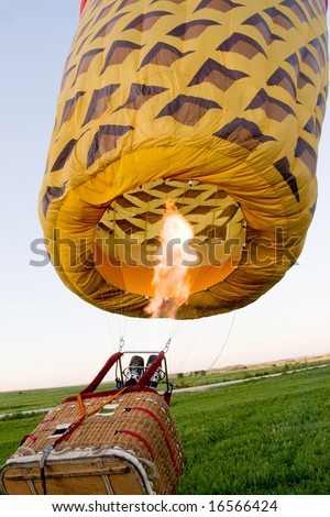 fire for inflating of big balloon with basket on the ground
