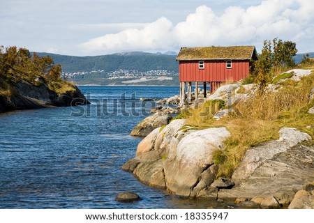 Red wooden house on sea coast. North Sea, Norway
