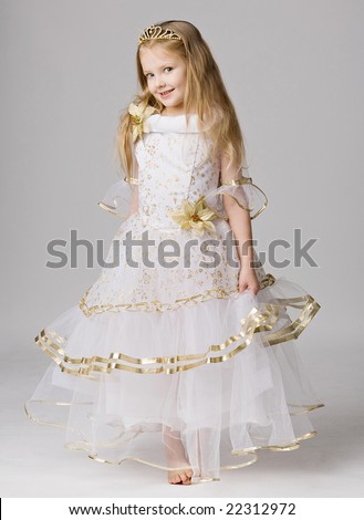 beautiful little girl in princess dress with long hair barefoot stand on grey background