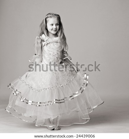 beautiful little girl in dress of princess with diadem on long hair barefoot stand isolated on white