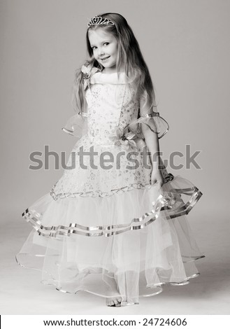 beautiful little girl in princess dress with long hair barefoot stand on grey background