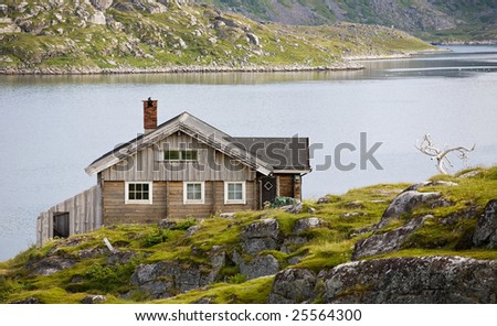 single wooden house standing on  riverside