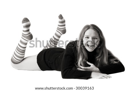 beautiful smiling girl in black sweater and long striped socks lies on the floor, isolated on white