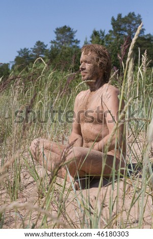 man smudged as masking sitting in yoga meditation pose on nature background