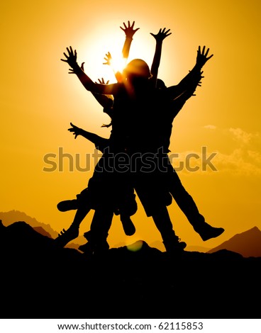 black silhouette of people group in happy jump on orange sunset sky and desert mountain background