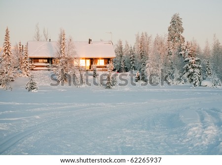 wooden cottage in snow forest