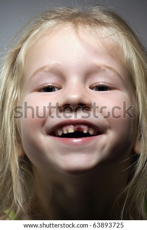 funny smiling little girl without one front tooth