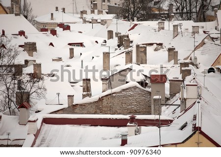 pattern of town roofs covered with snow with chimneys, aerial view