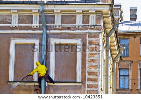 Cleaning service worker washing old building facade