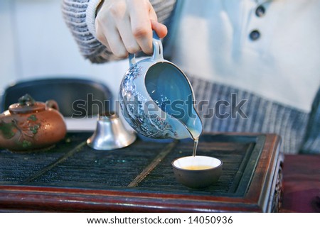 Man pouring green tea to traditional japanese cups