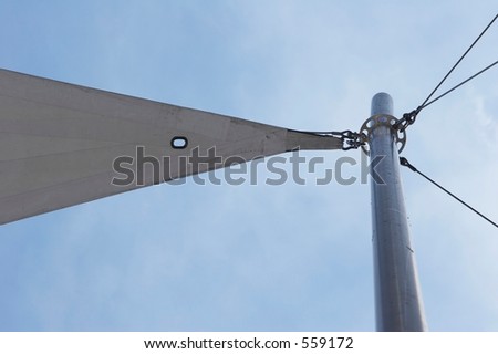Flag pole with ropes and tent sail against blue cloudy sky