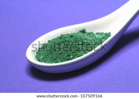 poisoned colored spice on a porcelain spoon