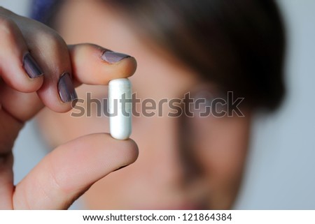 girl with a plain capsule in her hand
