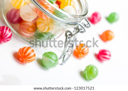 a selection of handmade colorful round candies in a glass vessel