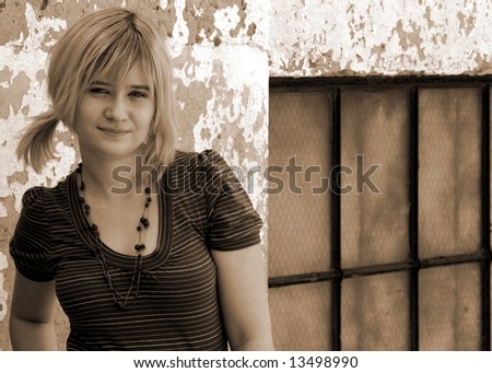 Cute young lady with pony tail, in an alleyway sepia toned