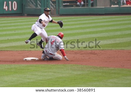 PITTSBURGH - SEPTEMBER 24 : Luis Cruz of Pittsburgh Pirates completes a double play as Brandon Phillips of thet Cincinnati Reds slides on September 24, 2009 in Pittsburgh, PA.