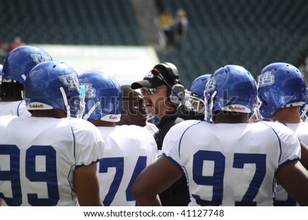 PHILADELPHIA, PA. - SEPTEMBER 26 : University of Buffalo defensive line coach, Brian Mohnsen, talks to his players on the sidelines on September 26, 2009 in Philadelphia, PA.
