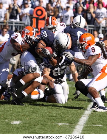 UNIVERSITY PARK, PA - OCT 9: Penn State's Evan Royster #22 is tackled by a host of Illinois players  during a loss at Beaver Stadium October 9, 2010 in University Park, PA