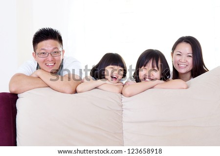 Asian family posing behind sofa