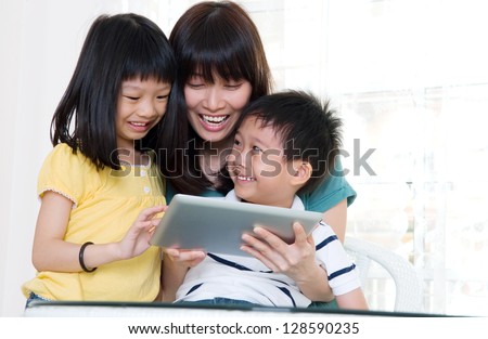 Asian mother and kids having fun with tablet computer