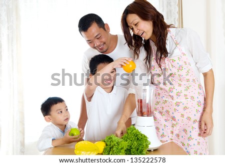 Asian boy helping mother in the kitchen