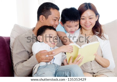 Asian family sharing a book