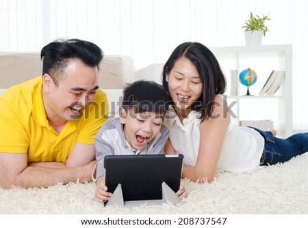 Asian family having fun with tablet computer