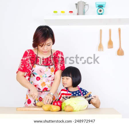 Asian mother and daughter cooking in the kitchen