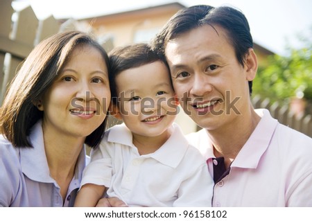 Asian parents hugging their son