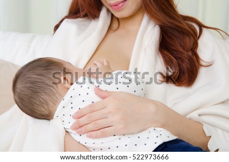 Six months old asian baby drinking breastmilk