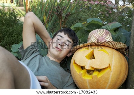 Young man sleeping with smiling orange pumpkin