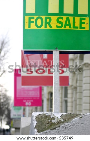 A row of real estate/estate agents\' property sale and sold boards.