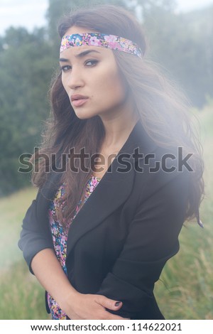 beautiful young woman posing outdoors during a fashion shooting. Special patches of light