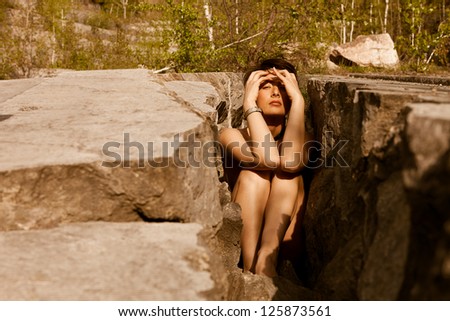 Sexy woman trapped in stones