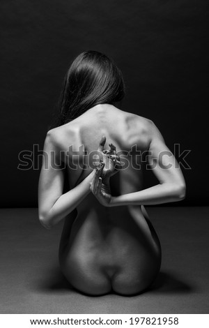 Beautiful back of young woman over dark background