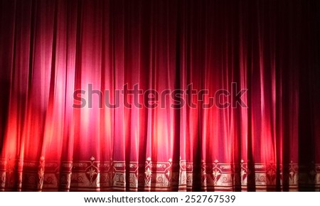 A closed red stage curtain in a small theater. Mobile photo. Mobilestock