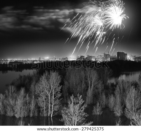 Night fireworks over flooded forest suburb of the city. Black-and-white fine art spring concept.