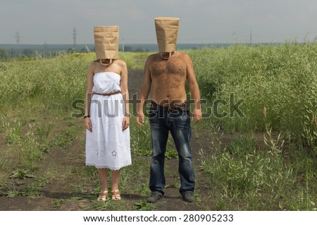 Couple with brown paper bags over their heads. Summer crazy concept.