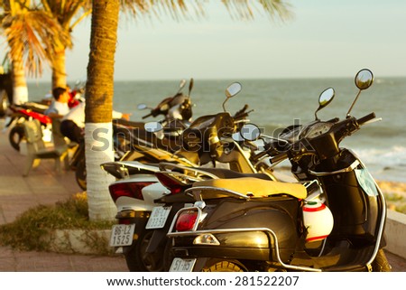 MUI NE, VIETNAM - DECEMBER 30: Scooters parked on parking with sea bay on the city beach during a sunset, City embankment, December 30, 2012, Mui Ne, Vietnam.